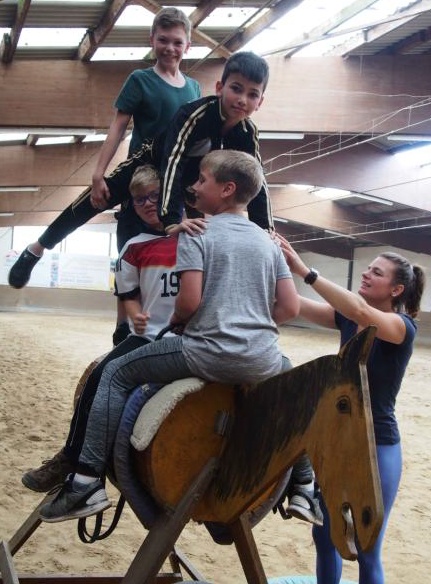 Adam, Blerton, Tim und Kyle mit einer akrobatischen Übung auf dem Holzpferd