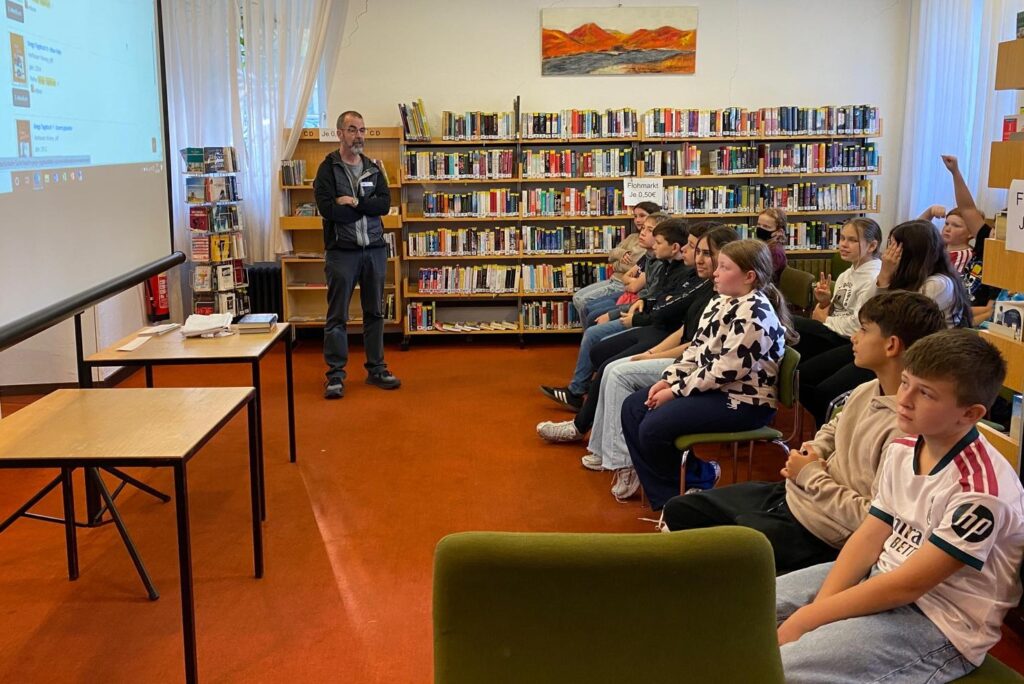 Der Leiter der Stadtbibliothek, Andreas Cronenberg, erläutert den Schülern in einem anschaulichen Vortrag das vielfältige Angebot der Bibliothek und zeigt am Beamer, wie die Mediensuche und Ausleihe über das Internet funktionieren.